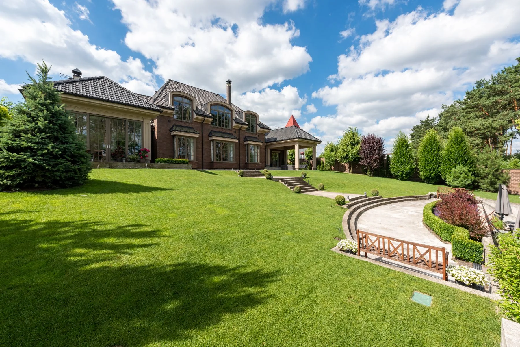 Manicured lawn, planting beds and stone steps beside a home